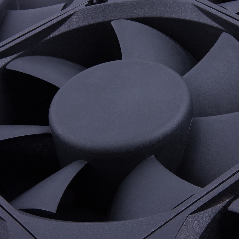 Gros plan sur un ventilateur de refroidissement noir mat. On distingue les pales courbées et le moyeu central texturé.